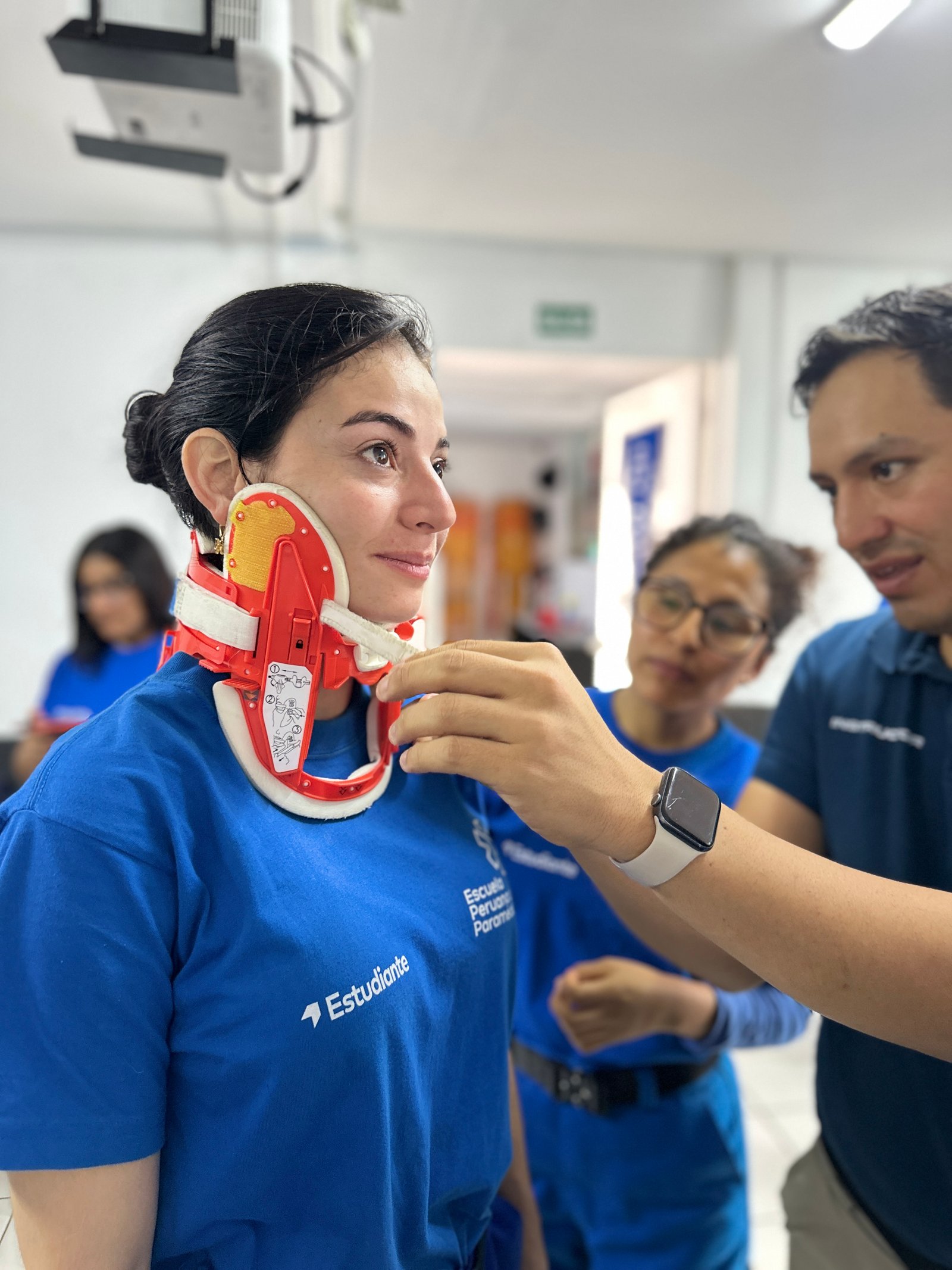 Instructores y estudiante de EPP durante entrenamiento de inmovilización cervical