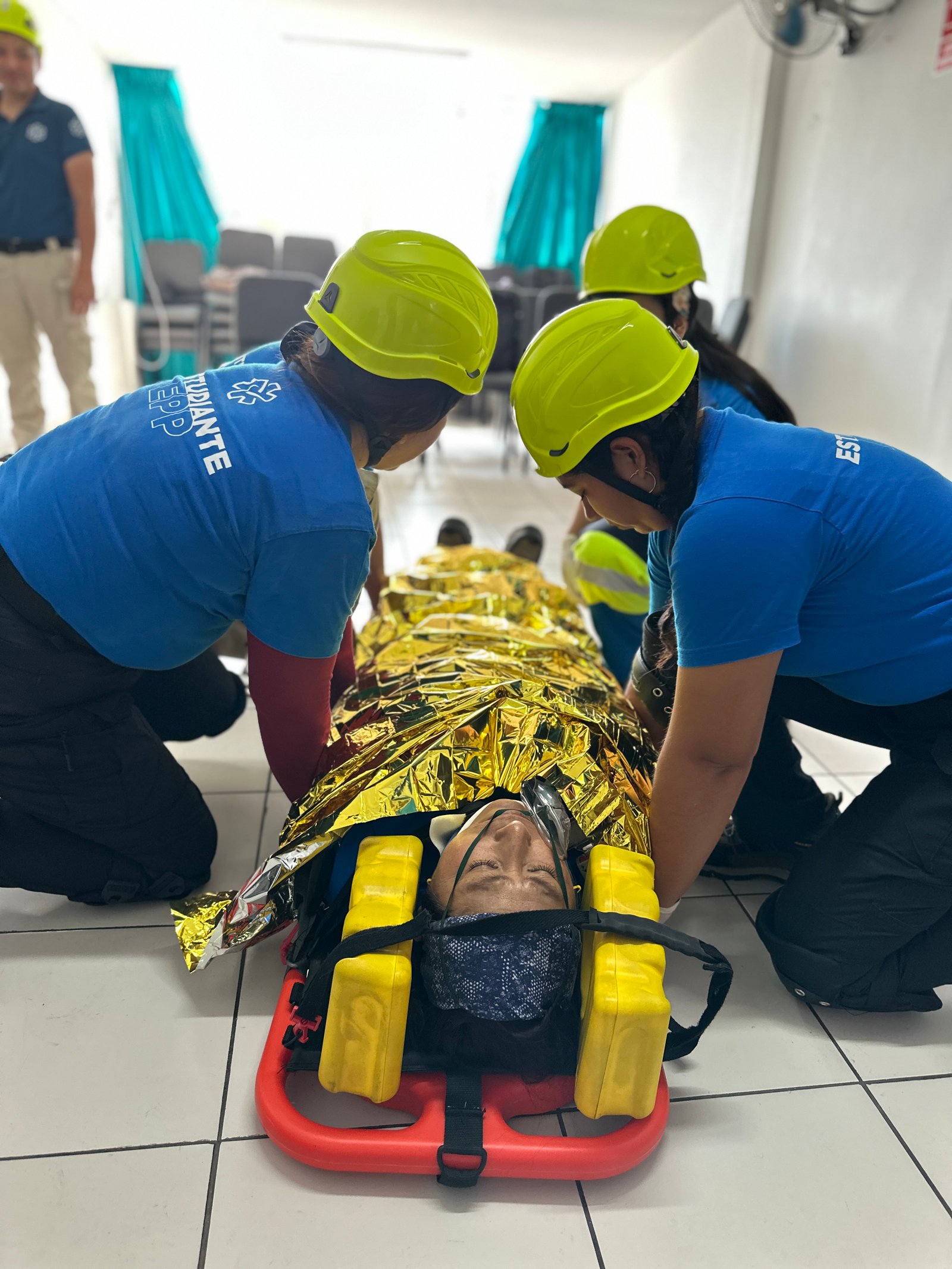 Estudiantes EPP entrenando el manejo de un paciente en camilla